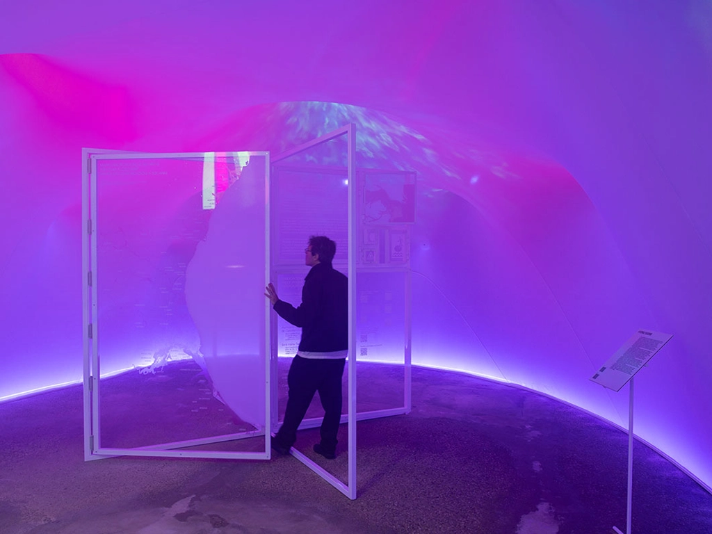 Visitante interactuando con los paneles dicroicos exposición en Parlaments de l'Agua Bienal 2025 proyecto ESSA PUNT