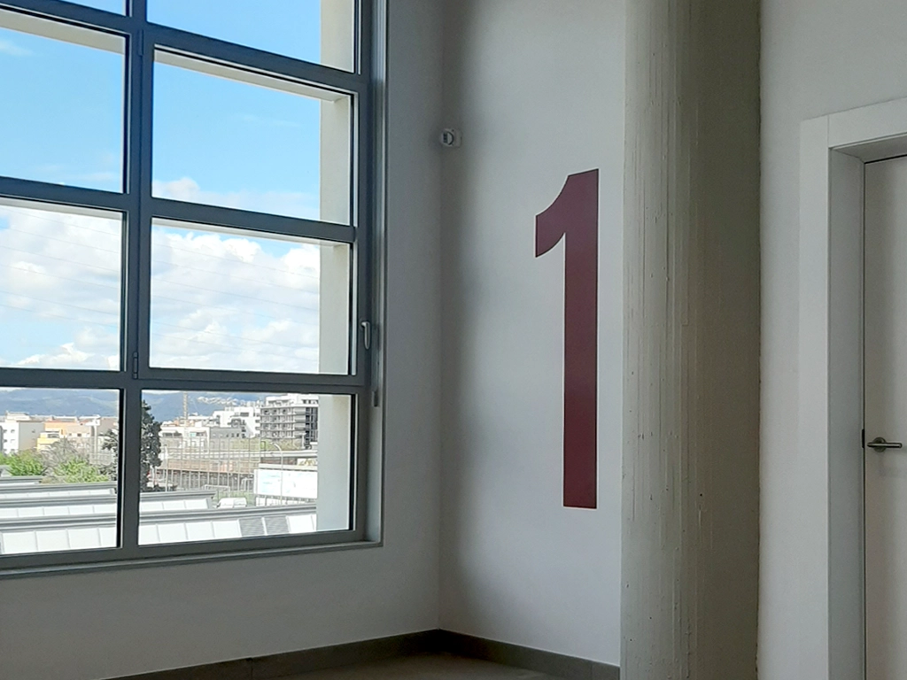 Vinilo de numeración de planta instalado en escaleras del Campus Esplugues proyecto ESSA PUNT