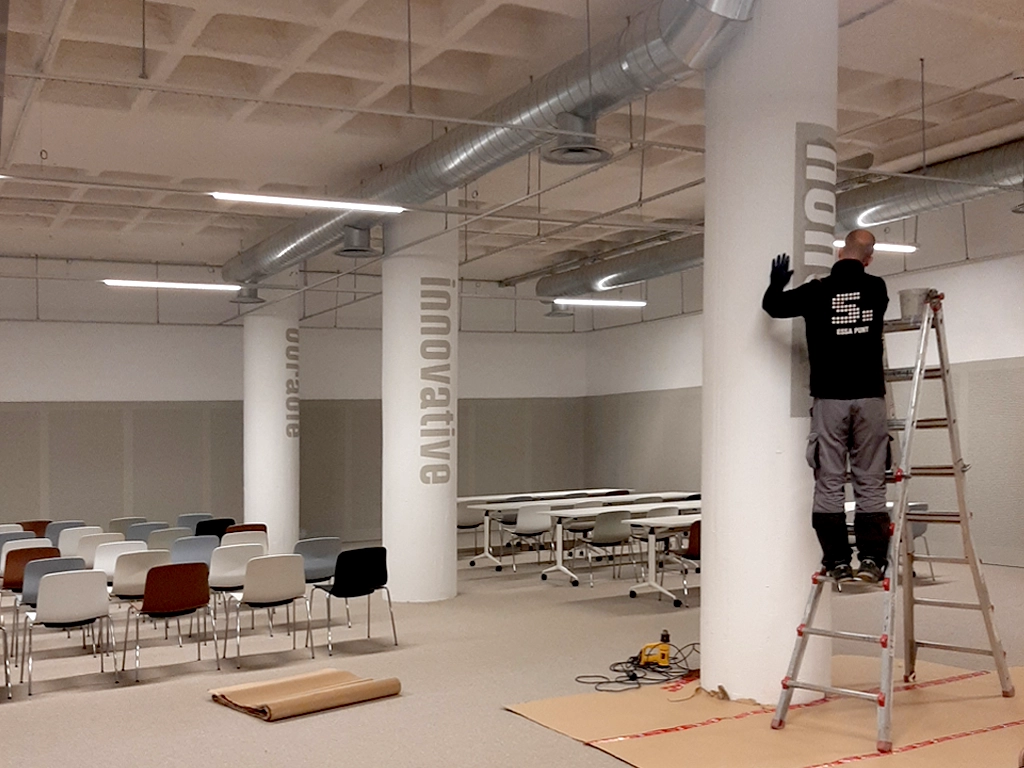 Procés aplicació de plantilles per a retolar amb pintura les columnes del Campus Esplugues proyecto ESSA PUNT