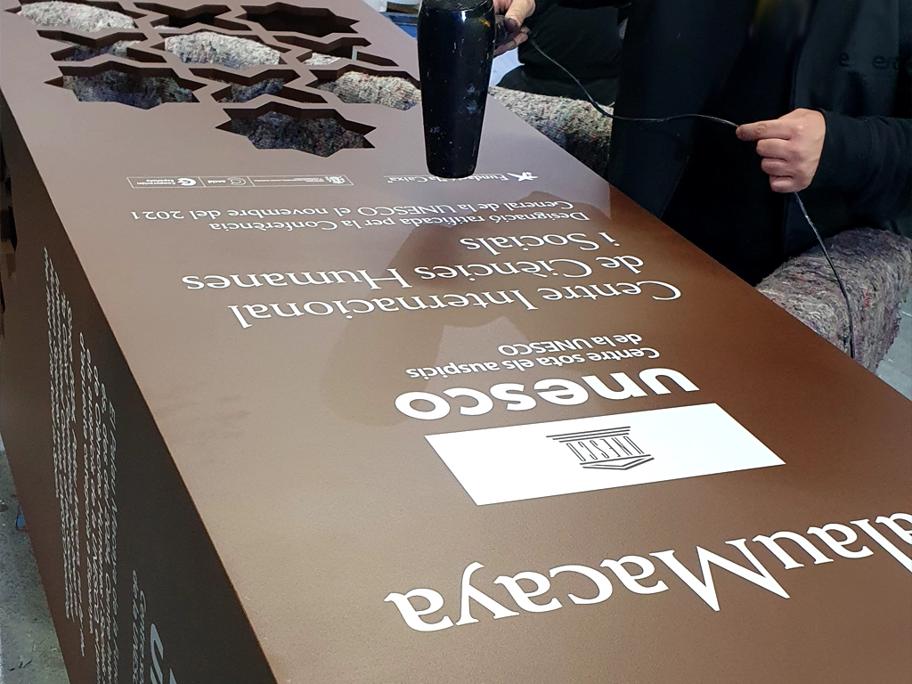 Processo retolació per serigrafia assecat del text del tòtem institucional Palau Macaya UNESCO Barcelona ESSA PUNT