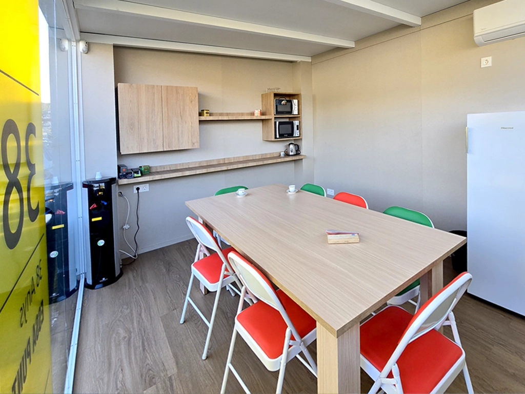Interior del nuevo comedor para trabajadores de ESSA PUNT con mesa compartida, sillas y zona office