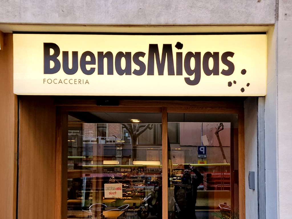 Rótulo exterior luminoso de uno de los locales de Buenas Migas 2025