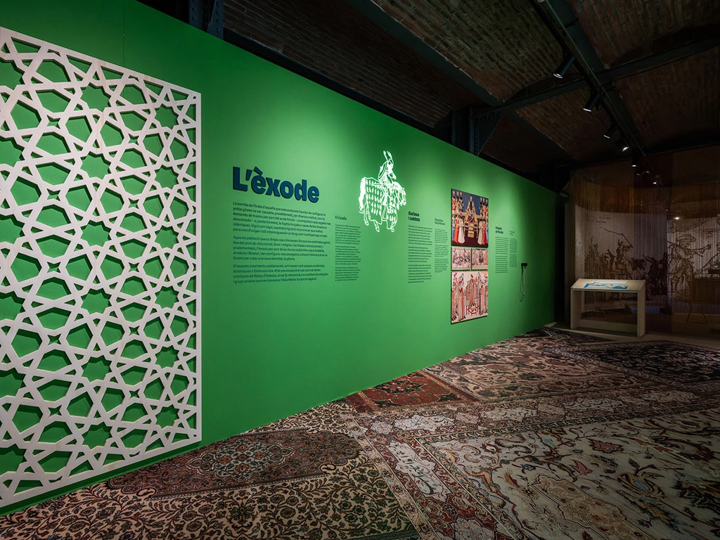 Pared con celosía y gráfica vinilos en el área del Éxodo en la exposición del Pueblo Gitano