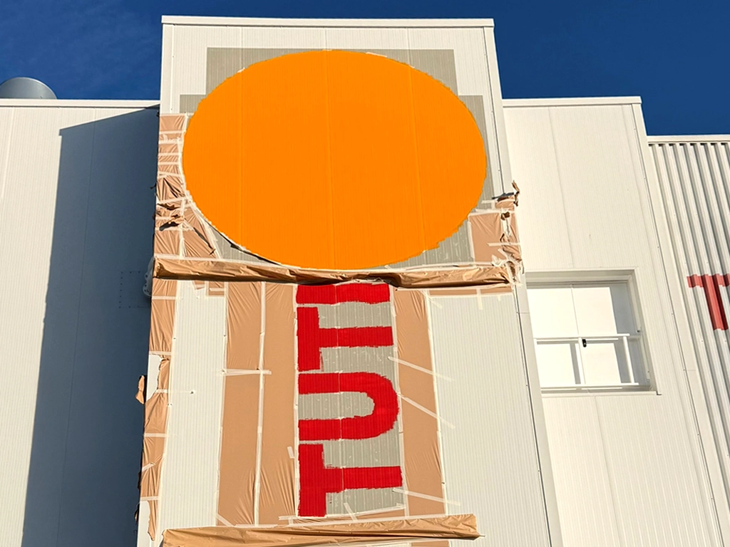 Procés pintat del cercle del logotip TUTICHIP en façana principal projecte ESSA PUNT